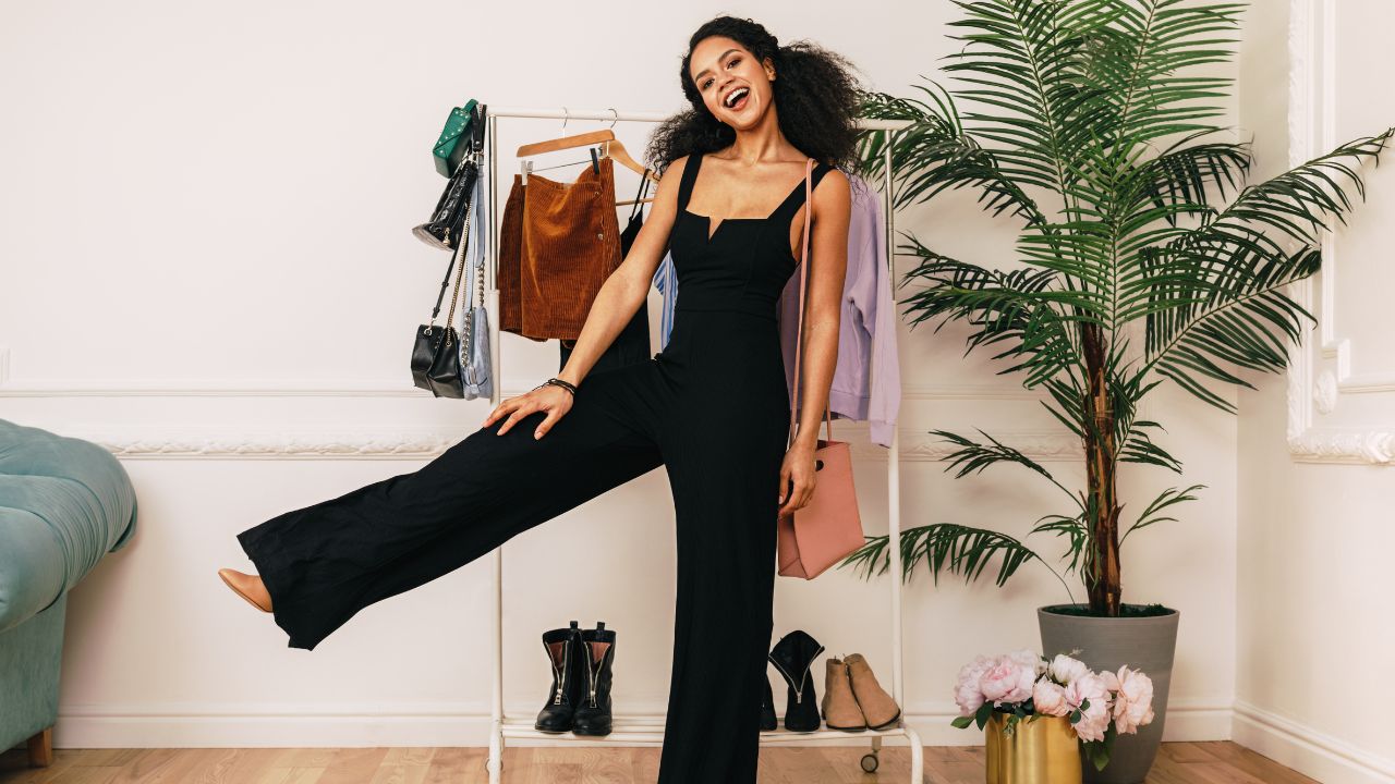Girl in Black Jumpsuit with Clothes Rack Behind